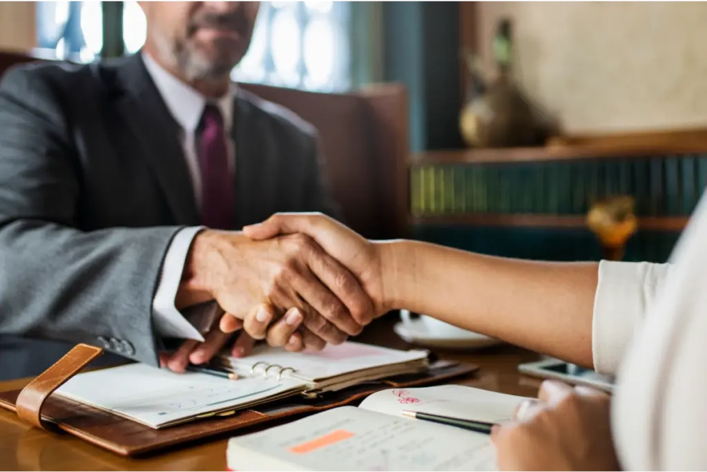 Advogado em escritório apertando mãos de cliente