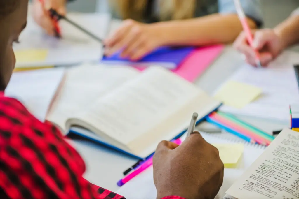 Pessoa estudando para concurso com livros sobre a mesa