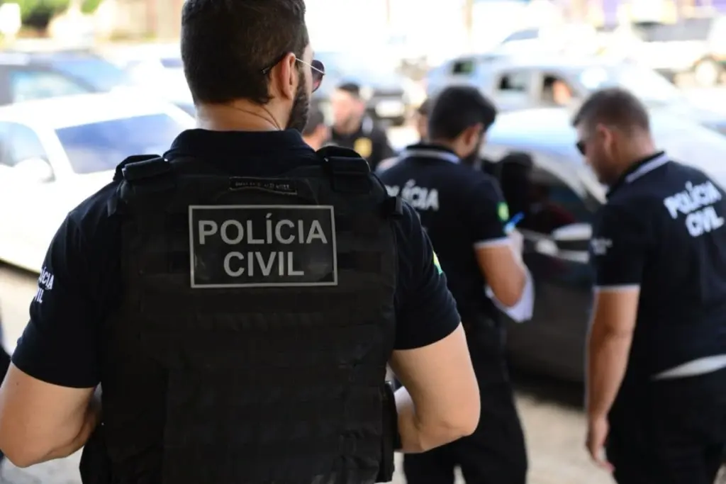 Policiais civis de costas com colete