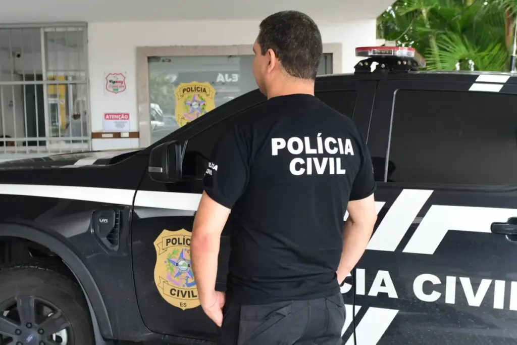 Oficial Investigador de Polícia ao lado de carro da Polícia Civil