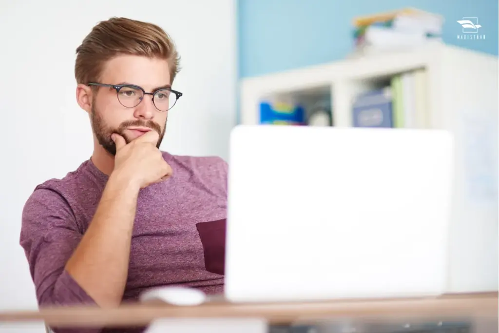 homem de óculos estudando em frente a um notebook