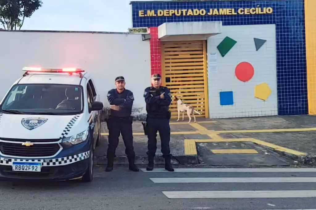 Guardas civis municipais de Goiânia e uma viatura em frente a um colégio