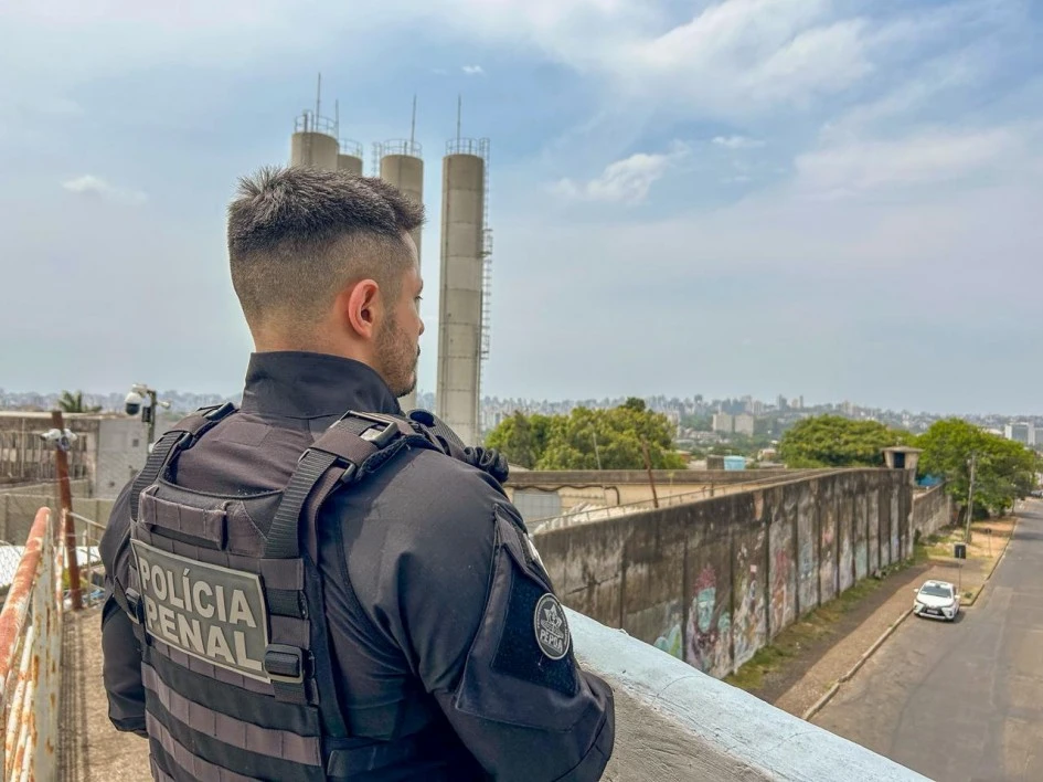 Polícia Penal parado em frente um viaduto